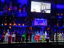 Bar outfitted with bottles of alcohol and a small aquarium under neon lights