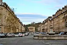 A long street of matching houses built from honey-coloured stone.