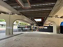 Underneath a concrete bridge with a road and construction site underneath