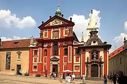 The abbey building, attached to the left of the red-colored Basilica of St. George