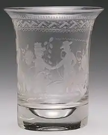 A frosted-glass beaker, uncoloured, with an engraved design.