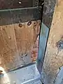 Door between living room and beaver pool, showing gnawing damage from beavers.