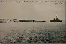 An Italian cruiser bombards two Ottoman ships with smoke billowing over the city.