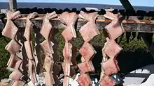 Blubber from a beluga whale hung to dry at Point Lay, Alaska