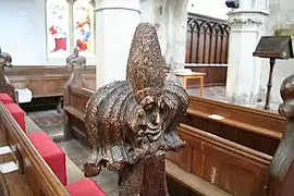 The carved poppyhead pew finials with grotesque faces