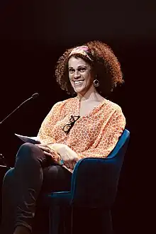 Bernardine Evaristo seated in a chair speaking at an event