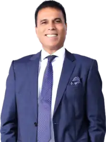 Colour photo headshot of Bikram Pandey wearing a blue suit with a white shirt and blue tie