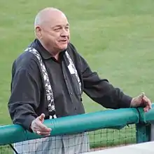 A man in a black shirt and suspenders and gray pants