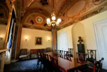 decorated room furnished with conference table, chairs, and sideboard