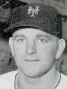 A man in a light baseball jersey and dark cap with an "NY" on the center