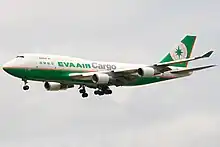 Double-deck aircraft in flight, with deployed landing gear.