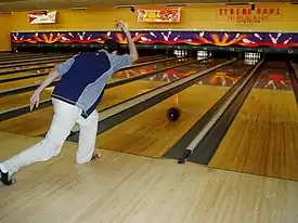 A ten-pin bowler releases the ball