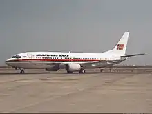 Boeing 737-400 with a white body, metallic belly and a red cheatline