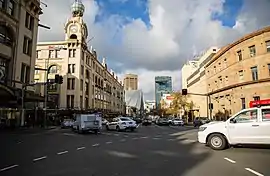 View down street with cars and trams