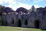 The east range of the cloister. From left: the parlour entrance; two west windows and door of chapter house; sacristy entrance.