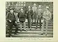 Sepia photograph of six gentlemen standing outside on pathway stairs