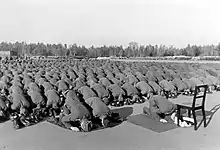 hundreds of men kneeling and bent over in Muslim prayer