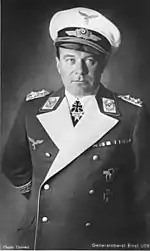 The head and upper body of a man wearing a military uniform, peaked cap and various military decorations.