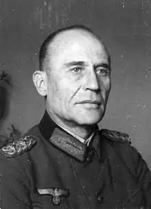 A man wearing a military uniform with an Iron Cross displayed at the front of his uniform collar.