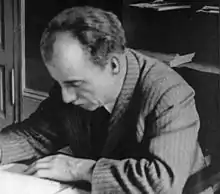 Huber seated at a desk, reading