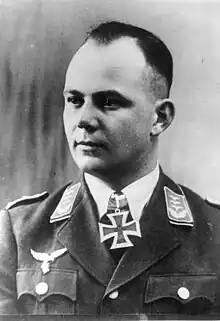 A man wearing a military uniform with an Iron Cross displayed at his neck.