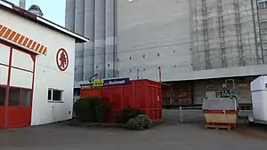 Shelter with grain elevator looming behind it