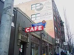 Photograph of a building's exterior, with a neon sign