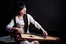 A lady playing the đàn tranh.