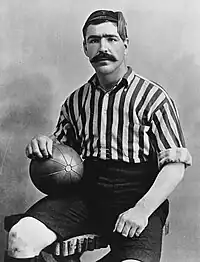 A black-and-white photograph of footballer Caesar Jenkyns, wearing a vertically-stripped shirt.