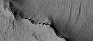 Close view of cap rock, as seen by HiRISE  The cap rock overhangs some layers.  The cap rock was more resistant to erosion, so it formed an overhang.