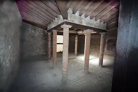 Atrium corinthium, multiple pillars. Small atrium of the House of Menander, Pompeii. Note how the diagonal valley rafters, at the mitered corners, are set lower than the smaller orthogonal rafters. This atrium is smaller than the clear-span Tuscan main atrium in the same house (floorplan model).