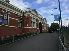 A paved ramp heading up towards the historical station building on platform 4