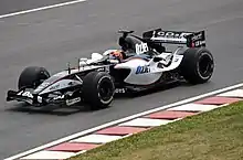 Christijan Albers driving the Minardi PS05 at the 2005 Canadian Grand Prix. OzJet is an aviation company owned by the CEO of Minardi from 2001 to 2005, Paul Stoddart.