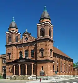 Brick church with twin corner towers and a raised central portico