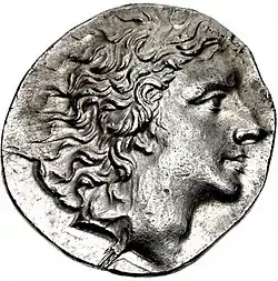 Photo of an ancient coin shows a clean-shaven man with wavy hair.