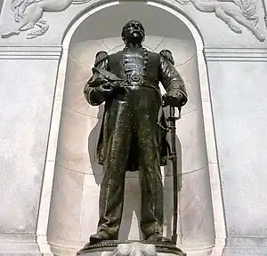 Bronze statue of a man standing with his hand on his sword at his hip