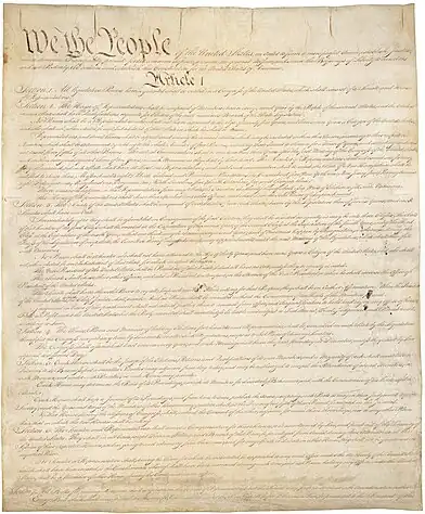 Light-brown parchment with "We the people" in large black cursive