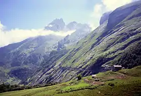 A green mountainside with a low-gradient road