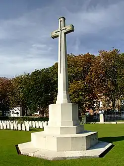 a stone cross with a metal longsword in the middle on an octagonal stone base.