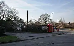 Road junction with red telephone box and white-painted public house