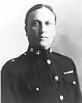 an image of a white male in his military uniform with no hat. Military style ribbons are clearly visible.