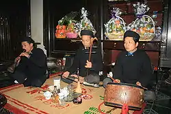 Image 8A trio of Vietnamese musicians performing together. The man on the far left plays kèn đám ma, the man in the middle plays the đàn nhị and the man on the right plays the trống chầu. (from Culture of Vietnam)