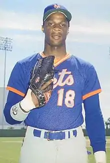 A man in a blue baseball jersey and cap and gray pants