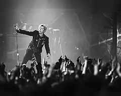 A man performing on a stage to a crowd of people