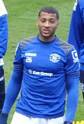 Dark-skinned man in blue sports kit