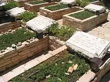 The standard Israeli military graves of David Elazar, Jonathan Netanyahu, and others with a yahrzeit candle in a box for each grave