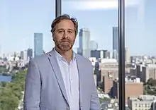 This is a picture of David H. Webber with the Boston skyline in the background.