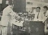 Ong Keng Seng, Executive Director of the school, lays the school flag on David Chen's casket.