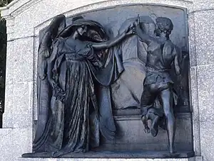 Bronze inlay in a stone monument showing an female angel and a male sculptor