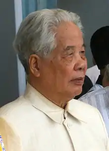 An old graying man wearing white jacket